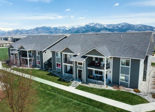 an aerial view of three houses with mountains in the background at Madison Park, Montana, 59718