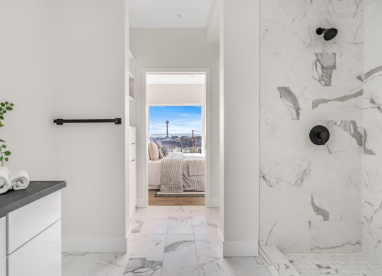 a bathroom with a view of a bed and a door to a bedroom  at Oslo, Seattle, WA