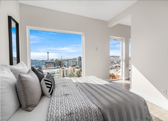 a bedroom with a bed and a view of the city  at Oslo, Seattle, 98102
