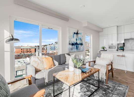 a living room with a couch and a coffee table and a kitchen  at Oslo, Seattle, WA, 98102