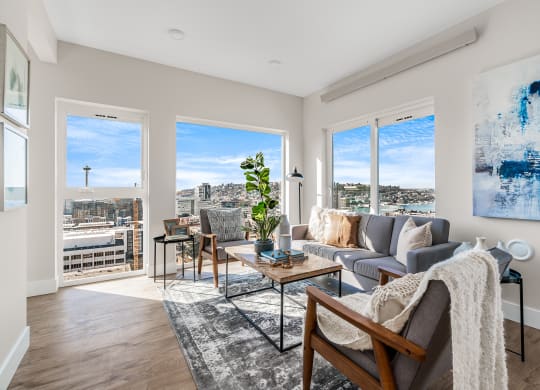 an open living room with a view of the city and a couch and chairs  at Oslo, Seattle, Washington
