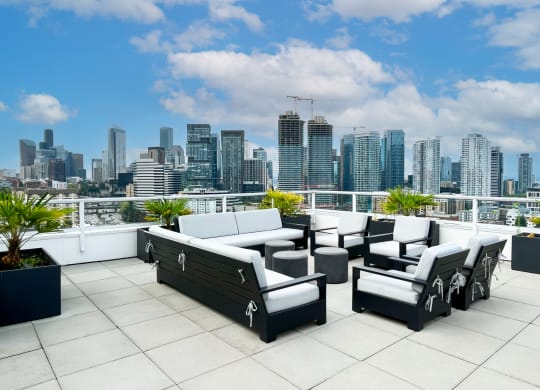a terrace with a view of a city and a patio with furniture  at Oslo, Seattle, WA