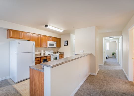 a long kitchen with white appliances and a granite counter top  at Quail Springs, West Richland, WA, 99353