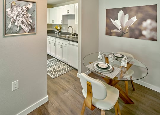 a dining room with a glass table and a kitchen at Quartz Creek, Washington, 98043