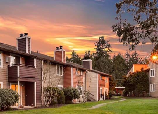 a row of houses with a sunset in the background at Quartz Creek, Mountlake Terrace, WA, 98043