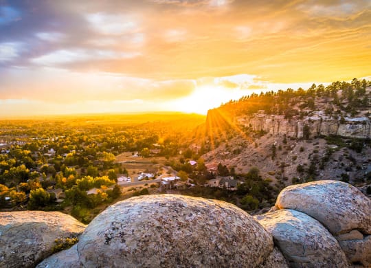 a view of the sunset over a city from a rocky hill at Rock Creek, Billings, MT
