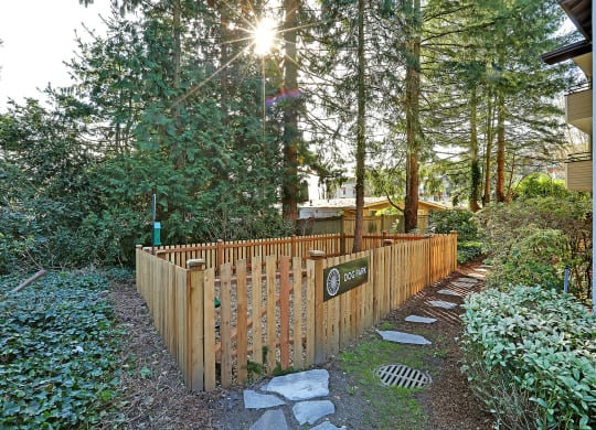 a wooden fence in front of a house with trees  at Townside Flats, Redmond, 98052