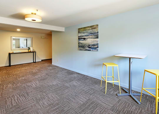 a community room with stools and a counter with a mirror  at Townside Flats, Redmond, Washington