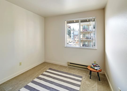 an empty room with a rug and a window  at Townside Flats, Redmond, 98052
