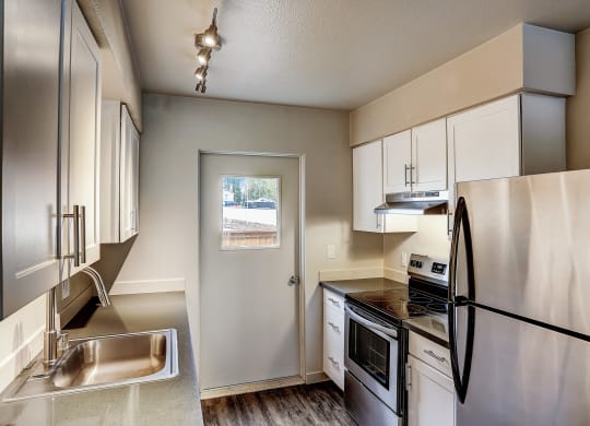 a kitchen with stainless steel appliances and white cabinets at Woodcreek, Poulsbo, WA