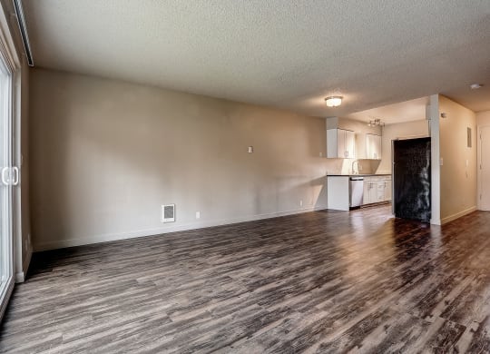the living room and kitchen of an apartment with wood flooring at Woodcreek, Poulsbo