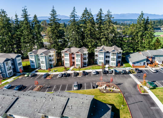an aerial view of an apartment complex with parking lot and trees at Woodcreek, Washington, 98370