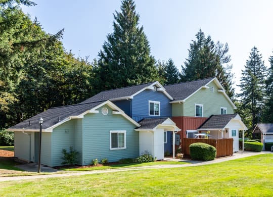 a blue house and a red and blue house with a yard and trees at Woodcreek, Poulsbo, WA