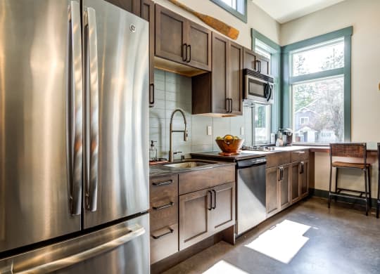 a kitchen with stainless steel appliances and wooden cabinets at Woodcreek, Poulsbo, WA 98370