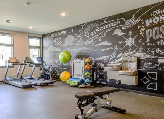 a workout room with cardio equipment and a chalkboard wall in a home gym at Woodcreek, Washington