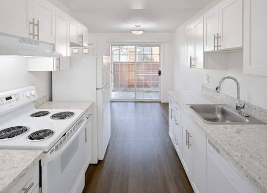 an empty kitchen with white cabinets and white appliances and a sink at Woodcreek, Washington, 98370