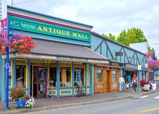 people walking down a street in front of an antique mall at Woodcreek, Poulsbo, WA 98370