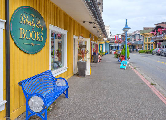 a blue bench in front of a yellow building at Woodcreek, Poulsbo, WA 98370