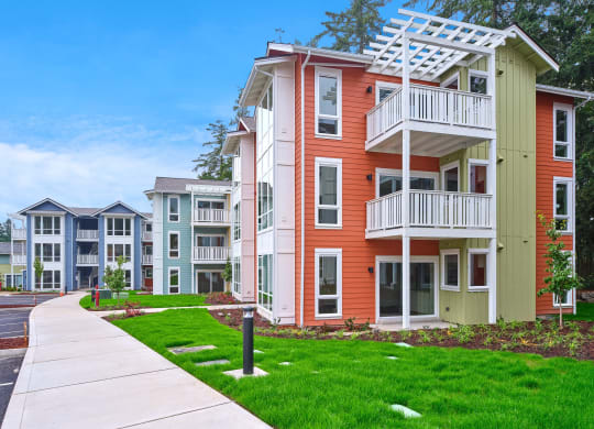 an apartment building with a sidewalk in front of it at Woodcreek, Poulsbo