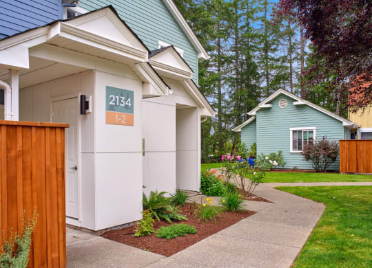 a white and blue house with a sidewalk in front of it at Woodcreek, Poulsbo Washington