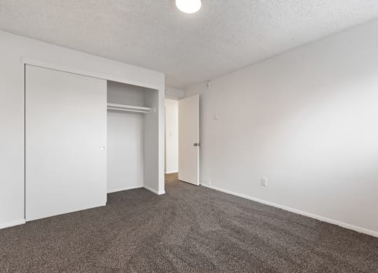 an empty living room with carpet and white walls