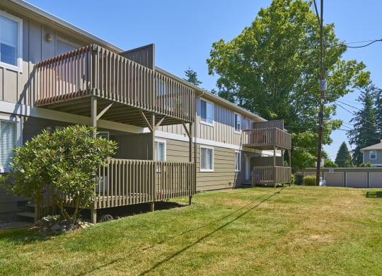 the back of two houses with balconies and a grass yard  at Woodhaven, Washington, 98203