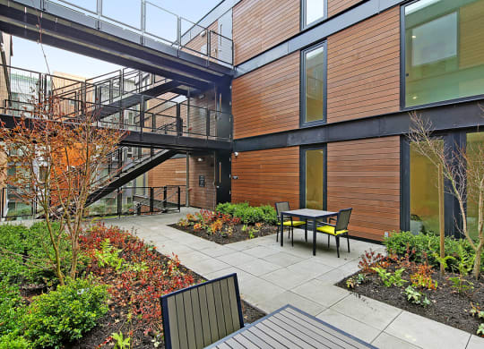 Exterior view of the community. Well maintained landscaping with pathways to building. Small seating area.at 19th & Mercer, Washington, 98112