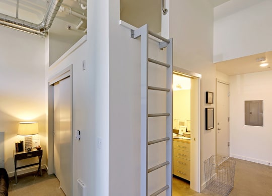 Loft apartment with vaulted ceilings. Staged bedroom on the left and a hallway to the kitchen and bathroom on the right.at 19th & Mercer, Washington, 98112