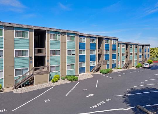 Outside apartments with numbered parking spots and well-maintained landscaping.
