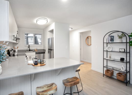 an open kitchen with a white counter top and a large island with two stools at Brix, Washington, 99362