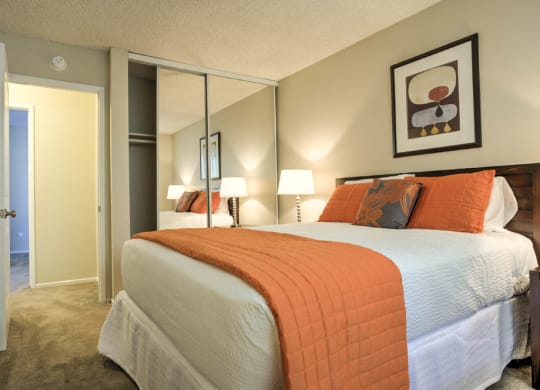 Bedroom with mirrored closet doors, full size bed and night stand at Pacific Sands, San Diego, California