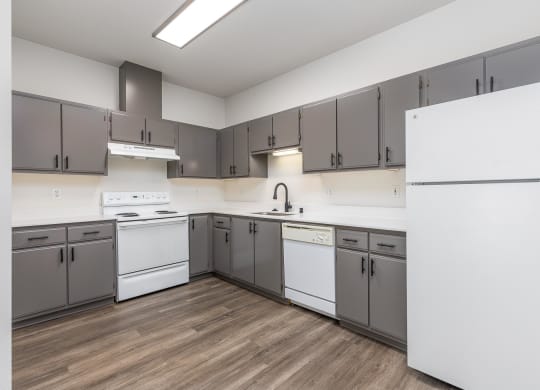 a large kitchen with white appliances and gray cabinets  at Shoreline Village, Richland, 99352