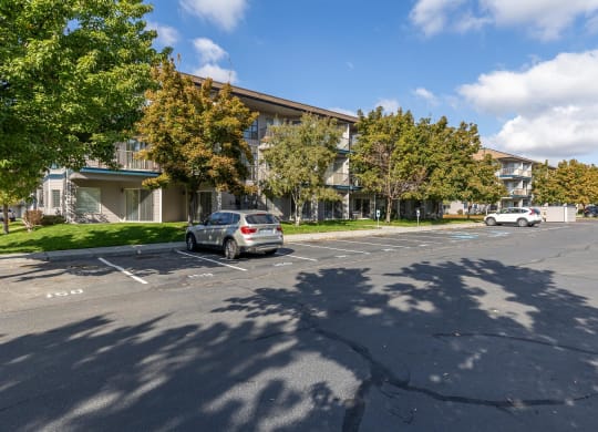 a parking lot with a car parked in front of an apartment building  at Shoreline Village, Richland, 99352