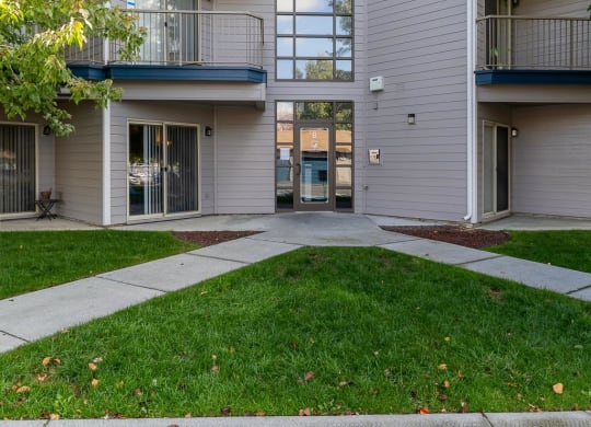 an exterior view of an apartment building with a sidewalk and grass  at Shoreline Village, Richland