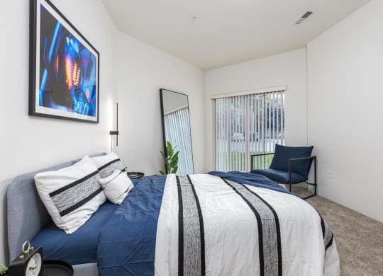 a bedroom with a blue and white bed and a chair  at Shoreline Village, Richland
