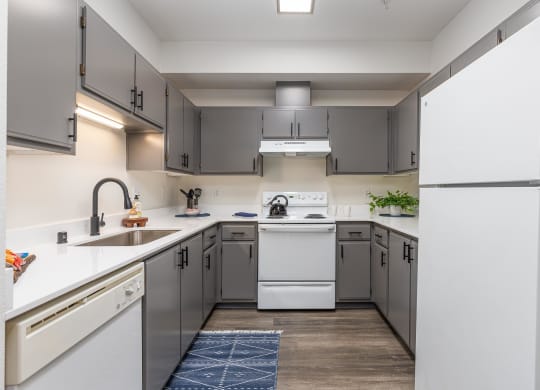a kitchen with white appliances and gray cabinets  at Shoreline Village, Richland, WA