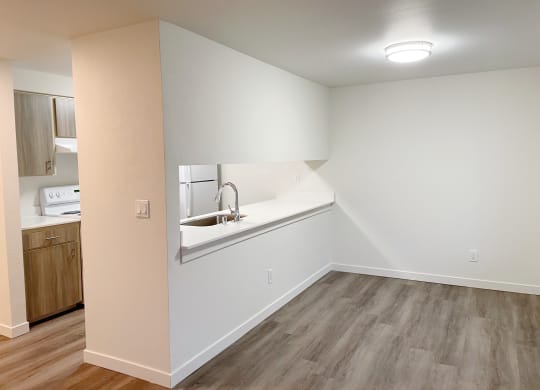 Dining area with wood-style flooring to the right, and the kitchen with a pass through window to the left.at The Trail, Washington