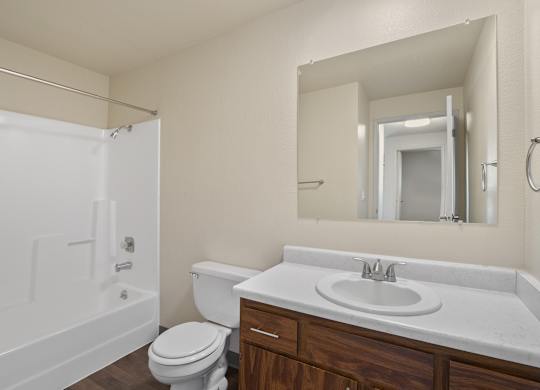 A white bathroom with a toilet, sink, and bathtub.