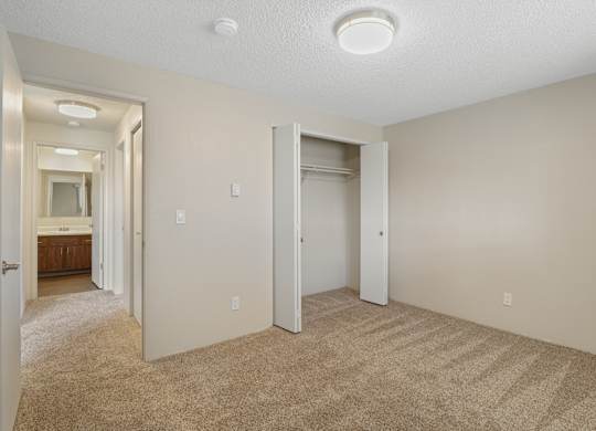 A bedroom with a carpeted floor and a ceiling light.