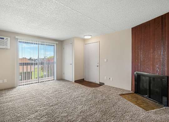 A living room with a flat screen TV and a sliding glass door.