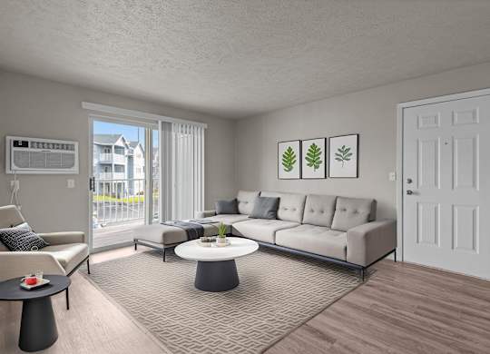 Staged living room in a 2-bedroom apartment at The Overlook Apartments in Post Falls, with a couch, coffee table, and framed wall art.