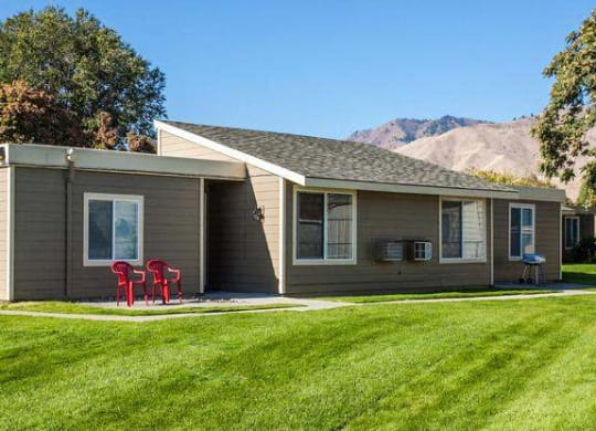 Exterior view of building with views of mountains in distance and grassy area.at Park View Apartments, Wenatchee, WA 98801