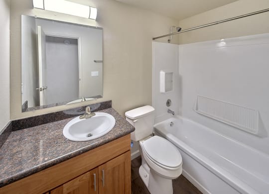 Full bathroom with light brown cabinets and light grey countertops.at Park View Apartments, Washington