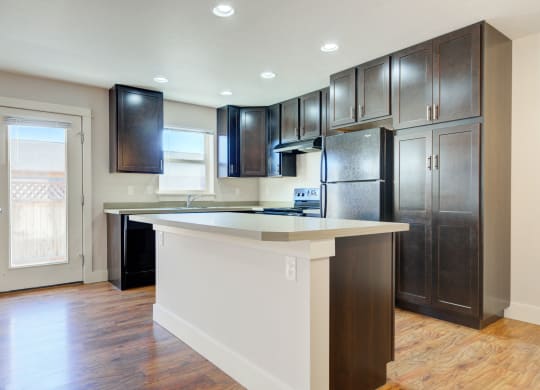 a kitchen with a large island and dark wood cabinets at Copper Pines, Bozeman, MT 
