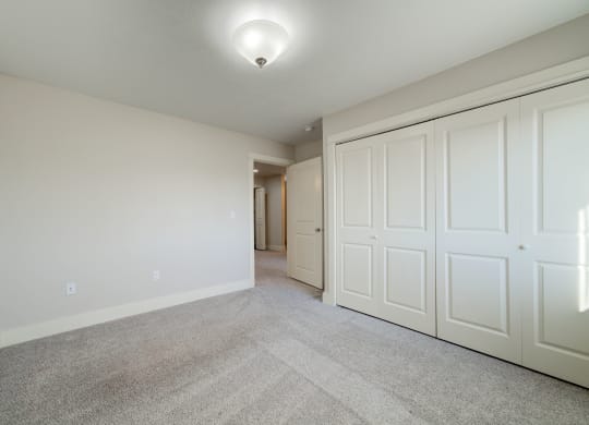 a bedroom with two closets and a carpeted floor at Copper Pines, Bozeman, MT