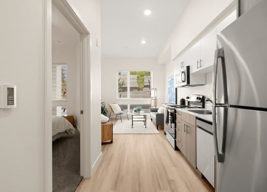 an open kitchen and living room with a refrigerator and stove at The Duo, University Place, 98466
