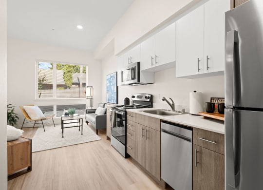 a kitchen with stainless steel appliances and white cabinets at The Duo, Washington