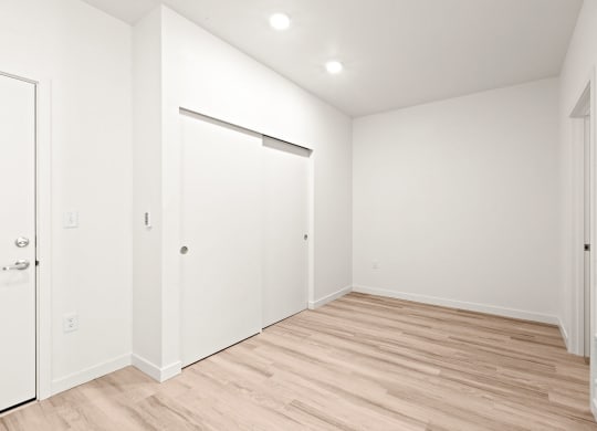 a living room with white walls and a wood floor at The Duo, University Place