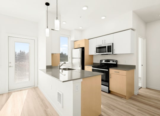 a kitchen with a large island and a window at The Duo, Washington