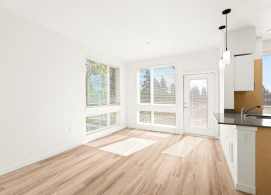a living room with a kitchen and a large window 